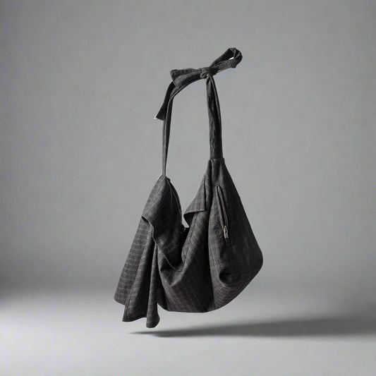 A dark gray plaid wool hobo bag with a tie strap and a draped silhouette.