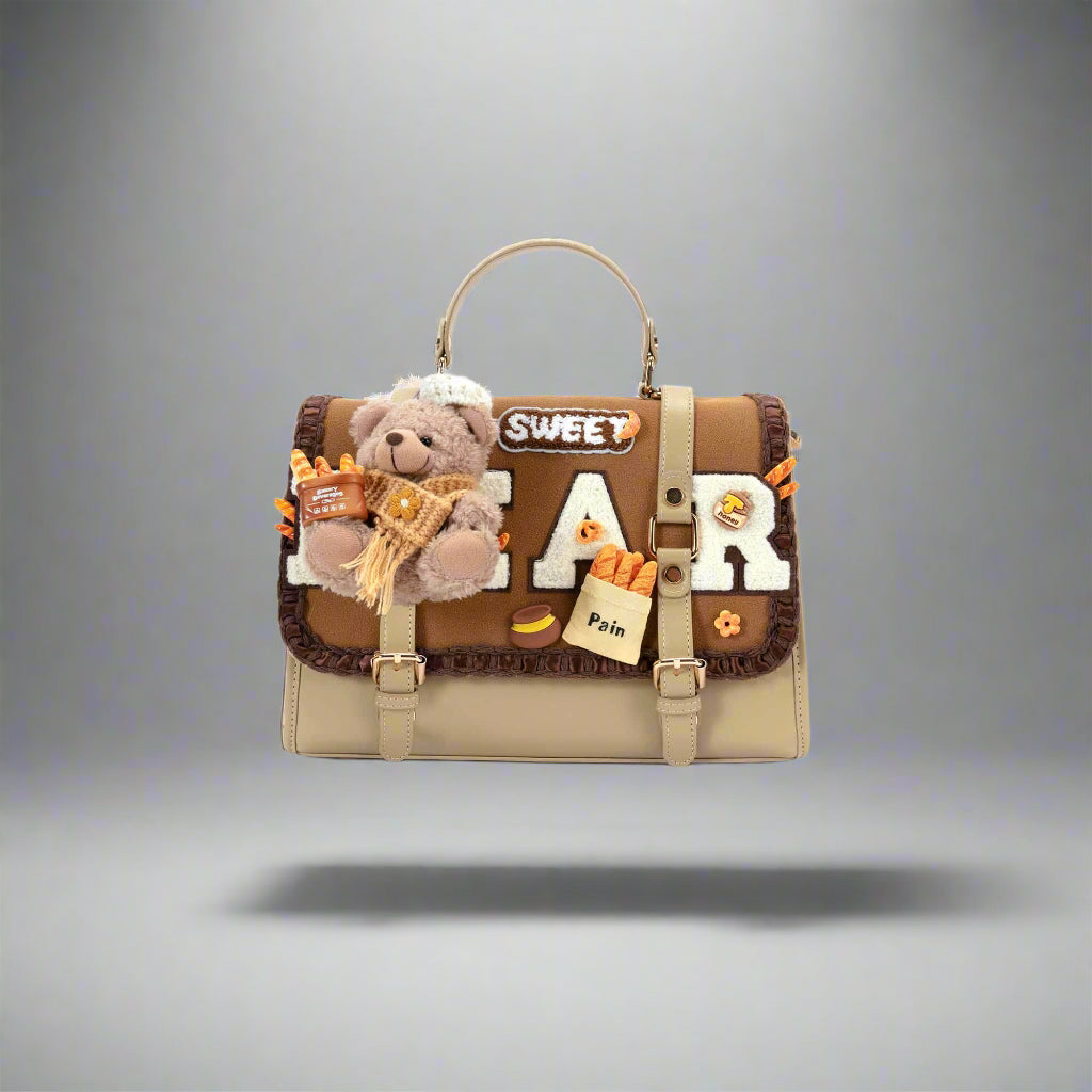 A beige and brown faux leather backpack with a plush teddy bear centerpiece, embroidered text 'SWEET BEAR', and faux food items attached to the flap.