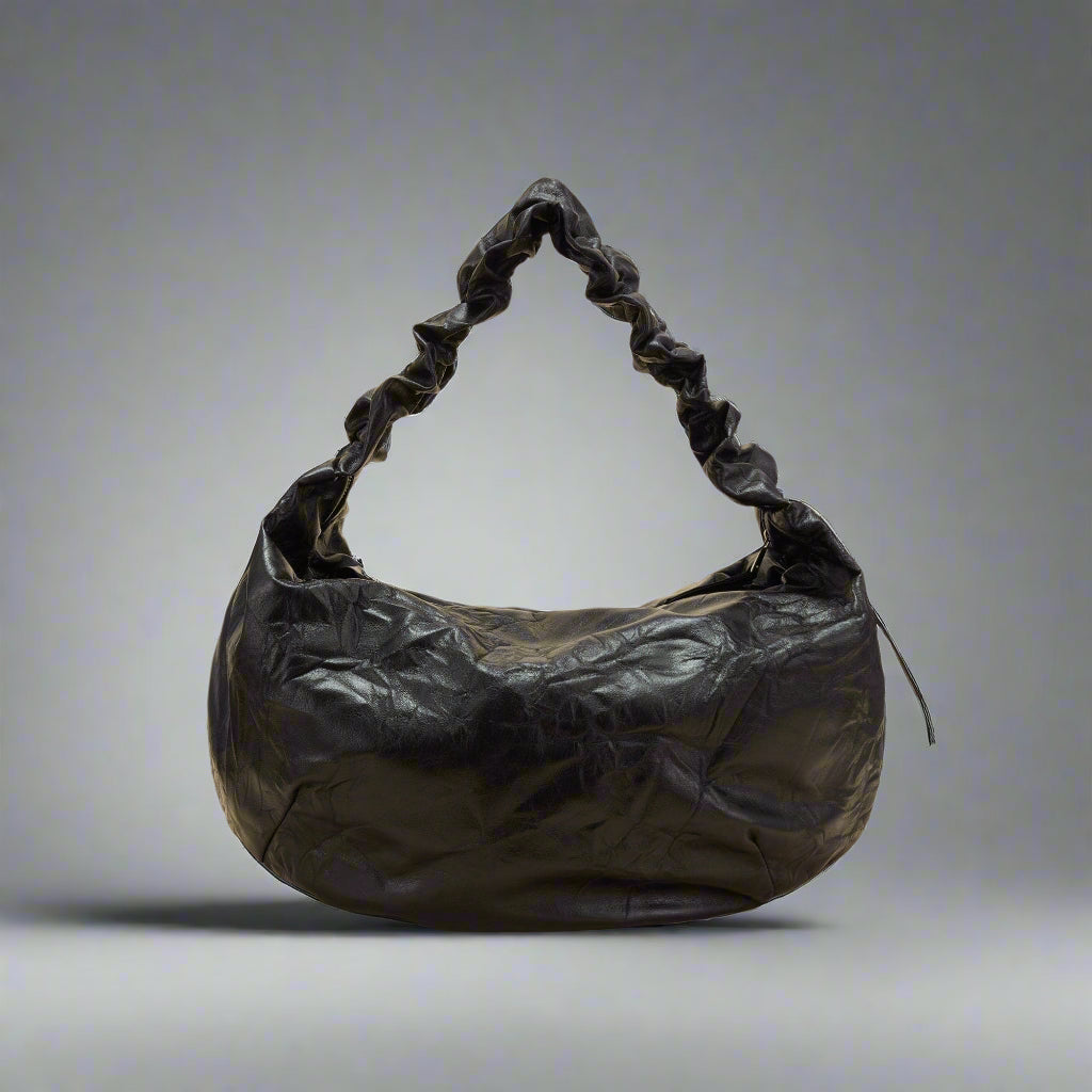 A black crescent-shaped tote bag with a luxurious leather strap and zipper closure.