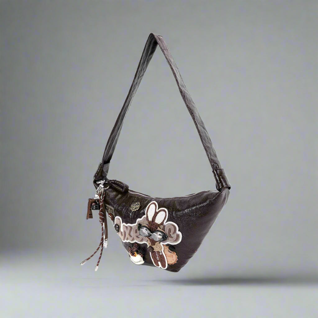 Brown handbag with floral design and decorative elements on a white background