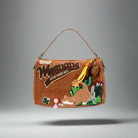 A brown shoulder bag with whimsical embroidered desert-themed graphics, including a cactus and desert animals, with a fixed-length top handle and shoulder strap.